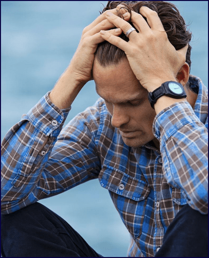 Depressed man with head in hands